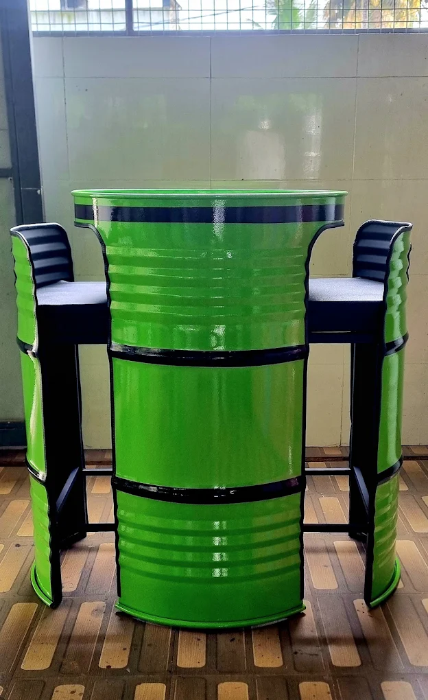 Bright green oil-drum bar table flanked by two green cushioned drum bar stools